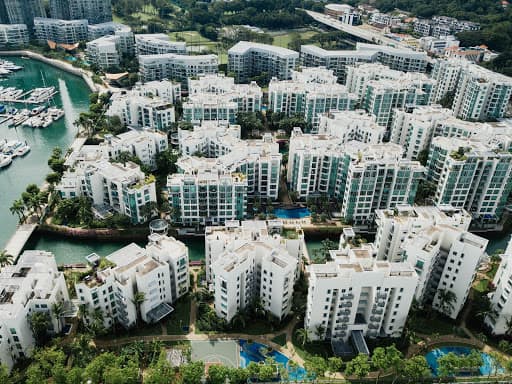 group of condo buildings, waterway, ocean, trees, blue water, white buildings